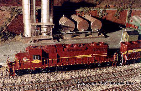 m215mod.jpg - A Duluth, Missabe and Iron Range ore drag roars by a bulk oil distributor.