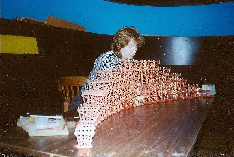 scan0034.jpg - Karen building her incredible scratchbuilt trestle. The planks were cut from a sheet of balsa wood. They were then stained, cut to size and assembled.